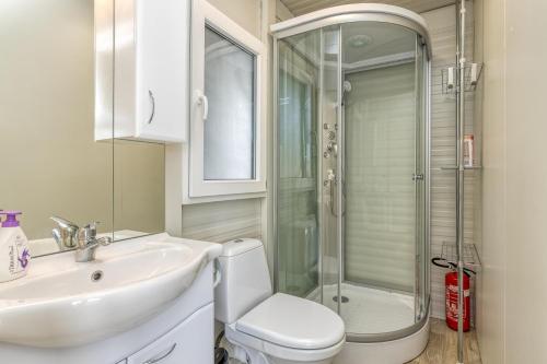 a bathroom with a toilet and a sink and a shower at Rooftop Home With Whirlpool & Sauna in Trebnje