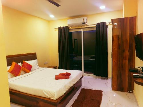 een slaapkamer met een bed en een raam met groene gordijnen bij Aroma Residency in Mahabaleshwar