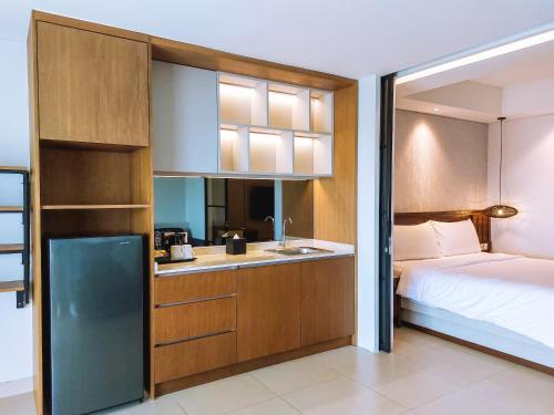 Un dormitorio con una cama y una cocina con fregadero. en Pearl Nusa Dua Suite, en Nusa Dua