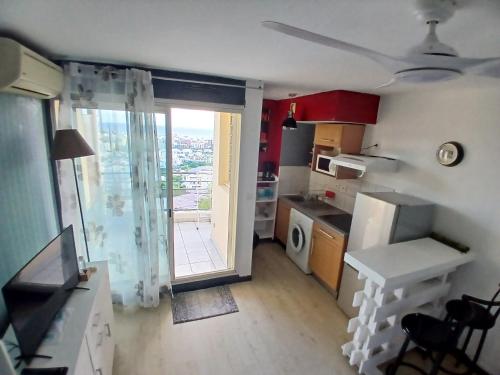 een keuken met een deur naar een balkon bij Agréable et tranquille studio vue mer in Saint-Denis