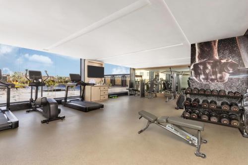 an apartment gym with cardio equipment and a large window at Novotel Jaipur Convention Centre in Jaipur