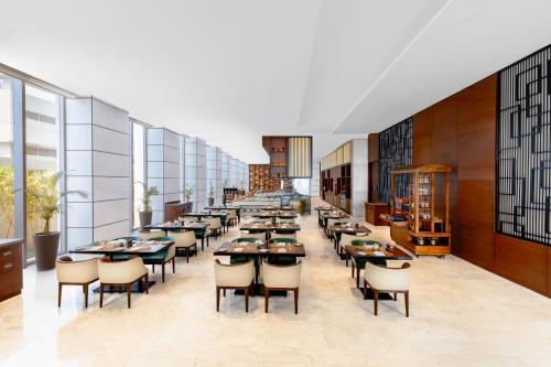 a long dining room with tables and chairs at Novotel Jaipur Convention Centre in Jaipur