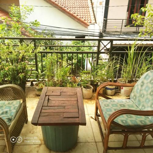 a patio with a wooden table and chairs and plants at PM Family Room in Jakarta