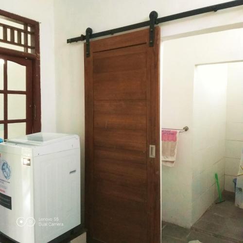 a wooden door in a bathroom with a washer and dryer at PM Family Room in Jakarta