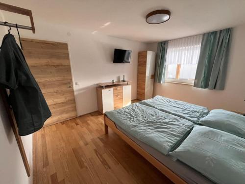 a bedroom with a large bed and a wooden floor at Meranerhof in Julbach