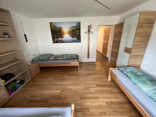 a bedroom with two beds and a wooden floor at Meranerhof in Julbach