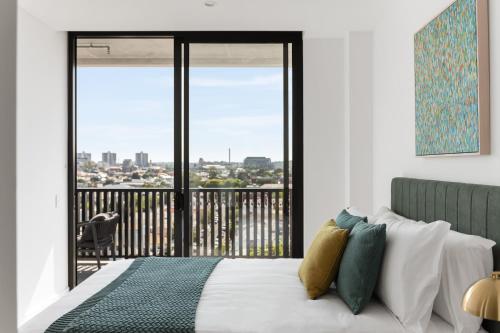 Un dormitorio con una cama y un balcón. en Urban Rest Richmond Swan Street, en Melbourne