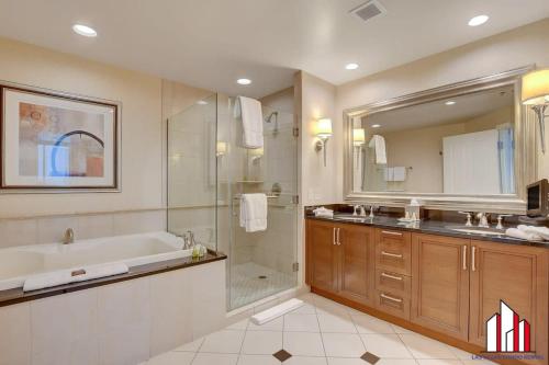 a bathroom with a tub and a shower and a sink at MGM Signature-34-819 F1 Track & Strip View Studio in Las Vegas