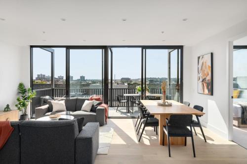 a living room with a couch and a table at Urban Rest Richmond Swan Street in Melbourne