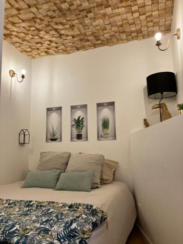 a bedroom with a bed with four pictures on the wall at Appartement secret , Cathédrale Saint Benigne Au calme in Dijon