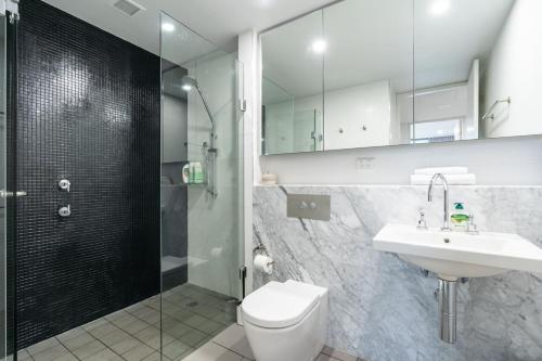 a bathroom with a toilet and a sink and a shower at Spacious 1BR APT, 8 mins to Old Parliament House in Kingston 