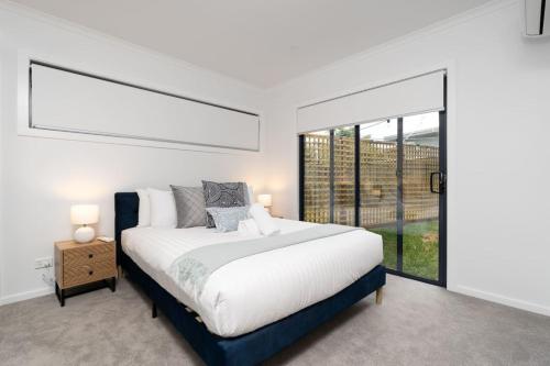 a bedroom with a large bed and a large window at Cosy 1 BR unit in Ainslie in Canberra