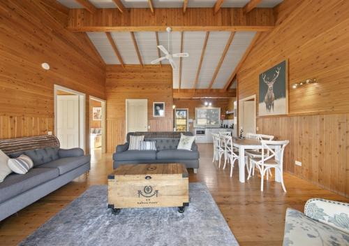 een woonkamer met een bank en een tafel bij North Lodge Clan Cottage in Pokolbin