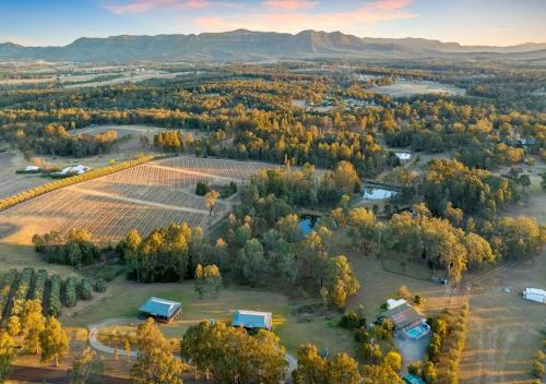 een luchtzicht op een boerderij met een veld en bomen bij North Lodge Clan Cottage in Pokolbin