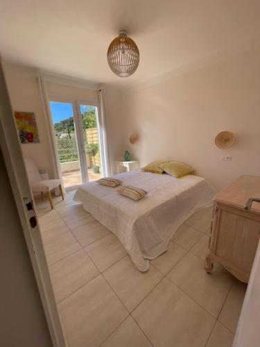a bedroom with a bed and a large window at Maison à la Naronne in Bandol