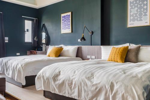two beds in a bedroom with blue walls at Chill Style Inn in Magong