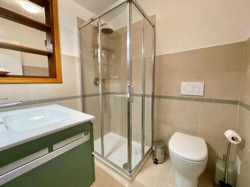 a bathroom with a shower and a toilet and a sink at Refreshing villa with private garden near the beach in Porto Santa Margherita di Caorle