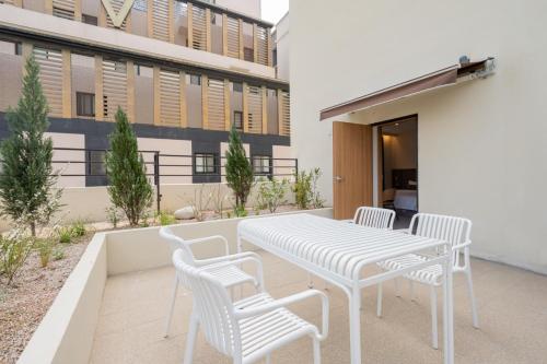 a white table and chairs on a patio at H-avenue Hotel Munhyeon in Busan