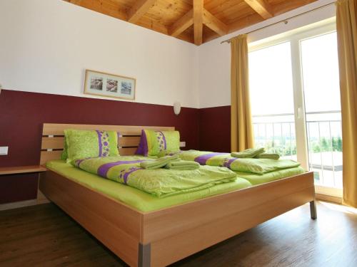 a bedroom with a large bed with green pillows at Spacious Chalet in Piesendorf with Sauna in Dürnberg