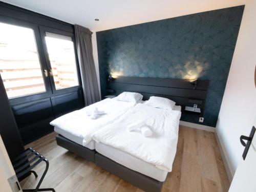 een slaapkamer met een groot bed met witte lakens bij Wellness Bungalow with whirlpool and sauna in Zevenhuizen