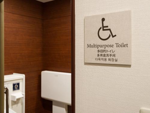 a sign on a bathroom door with a handicapped toilet at キップホテル湘南藤沢 in Kugenuma
