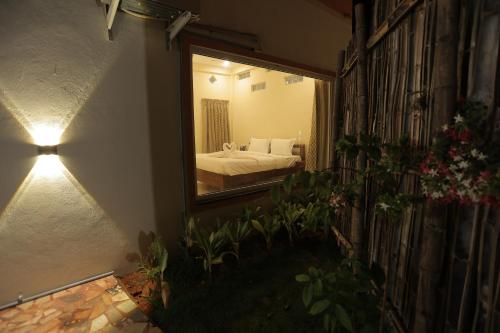 a bedroom with a bed and a mirror and plants at PALM PARADISE Beach Resort in Puducherry