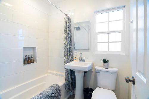 a bathroom with a sink and a toilet and a tub at Chic Studio Sleeps 4 Beverly Hills Adj in Los Angeles