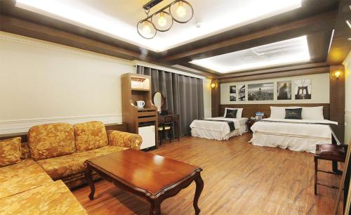 Prince hotel في Goseong: غرفة في الفندق مع أريكة وسريرين