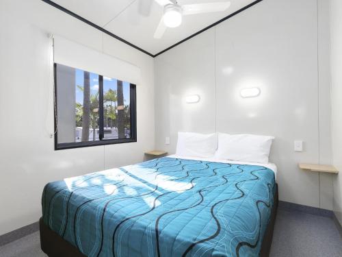 a bedroom with a bed with a blue comforter at Ingenia Holidays Noosa North in Tewantin