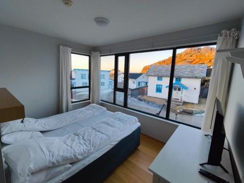 a bedroom with a bed and a desk and a window at Hamn i Senja in Hamn