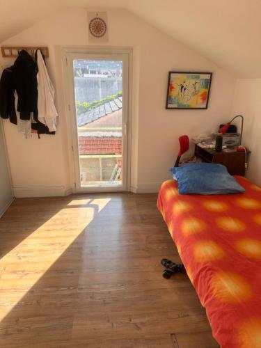 um quarto com uma cama e uma porta de vidro deslizante em Chambre au calme em Colombes