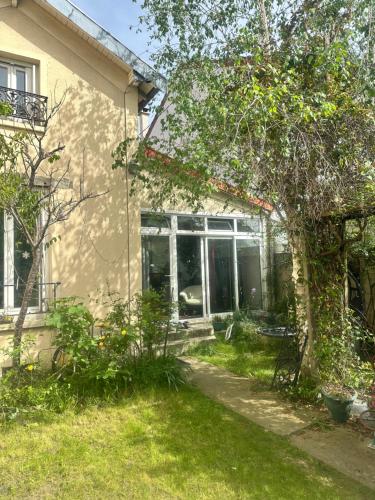 uma casa com um jardim em frente em Chambre au calme em Colombes
