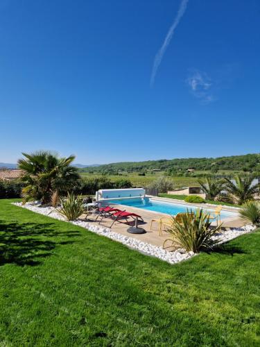 - une piscine avec des tables et des chaises dans la cour dans l'établissement Charmante Villa avec Piscine, à Saint-Marcel-dʼArdèche