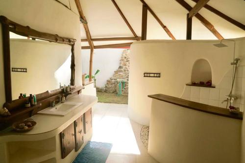 baño con lavabo y espejo en una habitación en Beach-Front Sumbawa Surf House en Lemonga