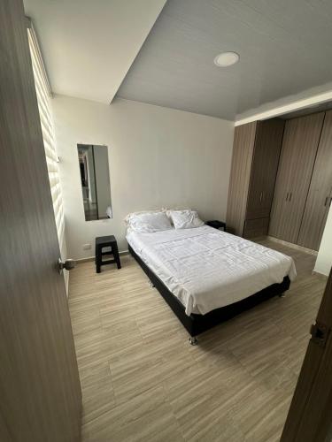Schlafzimmer mit einem Bett und einem Wandspiegel in der Unterkunft Ibague cowork in Ibagué
