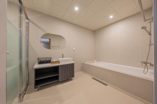 a bathroom with a tub and a sink and a shower at H-avenue Hotel Munhyeon in Busan