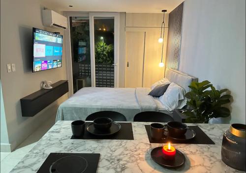 Un dormitorio con una cama y una mesa con una vela en Lujoso y cómodo apartamento, en Tegucigalpa