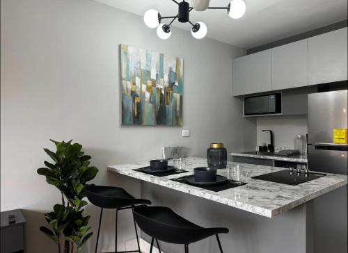 a kitchen with a counter with stools in it at Lujoso y cómodo apartamento in Tegucigalpa