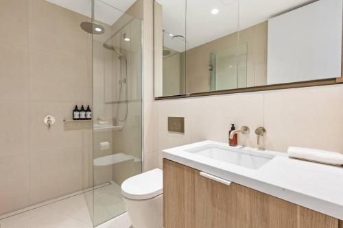 a bathroom with a sink and a toilet and a shower at Sea View 2BR w Best Rooftop Pool in Melb! in Melbourne