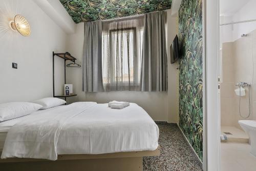 een slaapkamer met een bed en een badkamer met een wastafel bij 7ATHENS in Athene