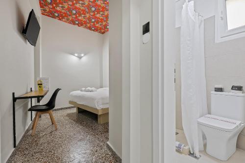een badkamer met een toilet en een slaapkamer met een bed bij 7ATHENS in Athene