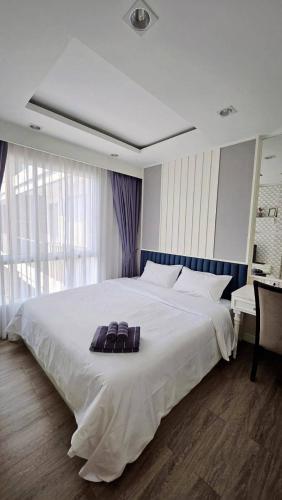 a large white bed in a room with a desk at The Blu X Seaview F6 R156 in Ban Bang Saen (1)