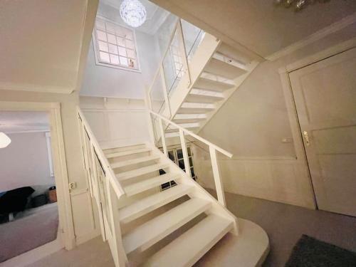 a white staircase in a room with a window at Traumhaus, Sauna, Whirlpool, grosse Terrasse mit Aussicht, Seeanstoss in Vagnhärad