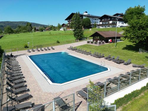 an overhead view of a swimming pool with chairs and a house at Hotel Lohninger-Schober 3 Stern Superior in Sankt Georgen im Attergau