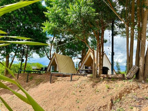 a campsite with a tent and a bench and trees at เคียงดาว โฮมสเตย์ แก่งกระจาน in Ban Song Phi Nong