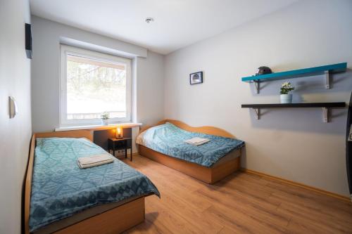 2 Betten in einem Zimmer mit Fenster in der Unterkunft Namelis ant Vilnojos ežero kranto in Sudervė