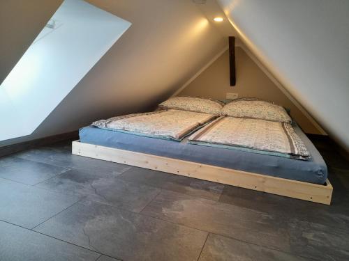 a bed sitting in the middle of a attic at Ferienwohnung am Kalten Bach in Dürrröhrsdorf