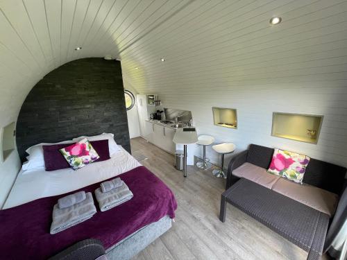 Un dormitorio con una cama y un sofá en una habitación. en Dilham Hall Retreats, en Dilham