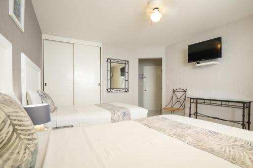 a bedroom with two beds and a flat screen tv at Hotel Master Club in Tequesquitengo