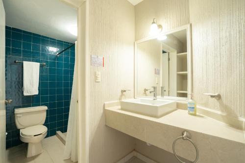 a bathroom with a sink and a toilet and a mirror at Hotel Master Club in Tequesquitengo